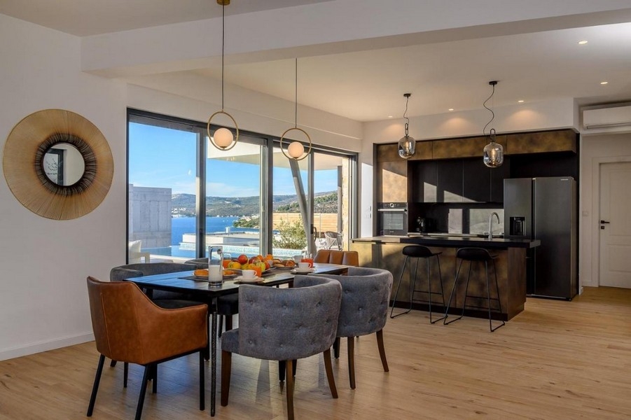 Jídelna vedle kuchyně s výhledem na bazén a moře