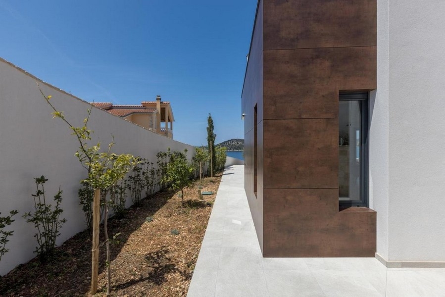 Boční pohled na vilu se zahradní cestou a výhledem na moře