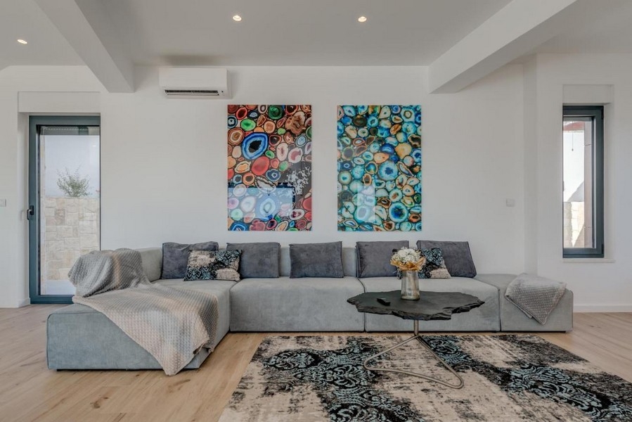 Moderní obývací pokoj s velkou pohovkou a nástěnnými malbami