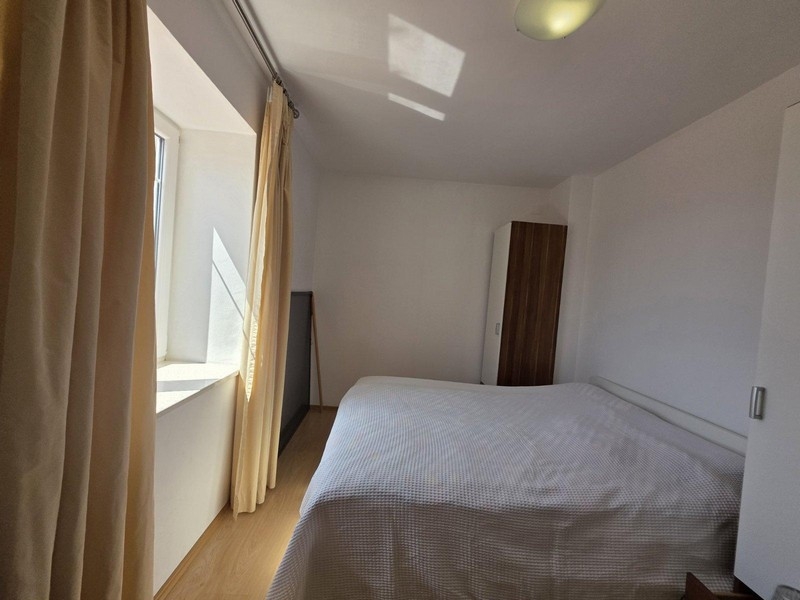 Světlá ložnice s manželskou postelí a šatní skříní