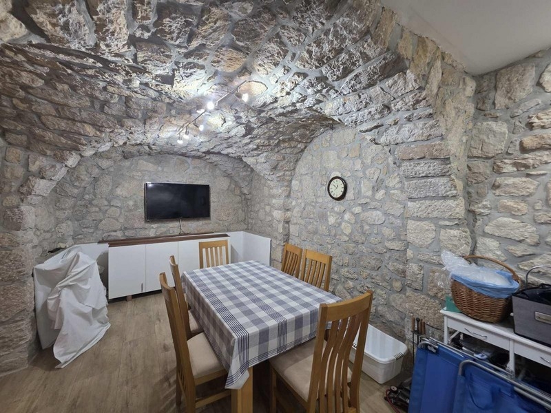 Zděná kamenná krčma s dřevěným stolem a židlemi