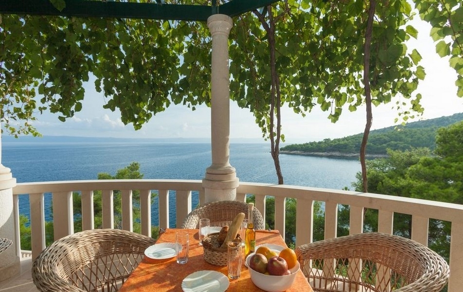 Krytá terasa s posezením a výhledem na moře