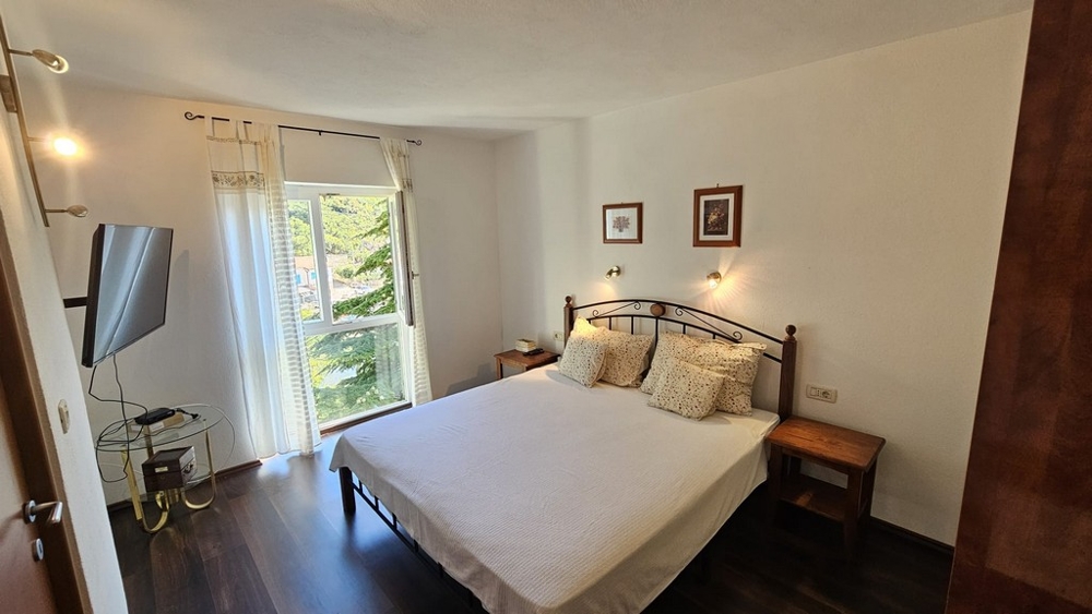 Ložnice s manželskou postelí a výhledem do zeleně