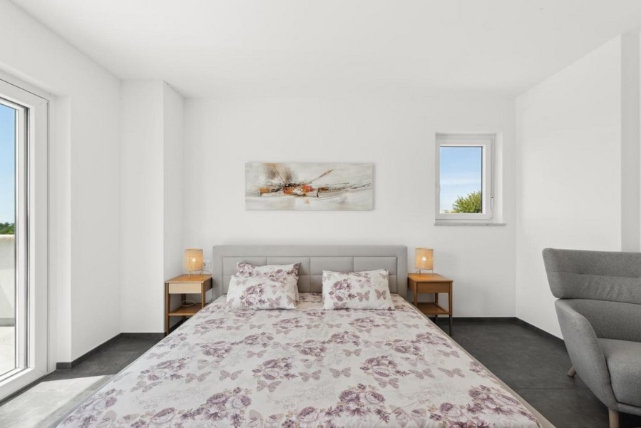 Ložnice s manželskou postelí a vstupem na balkon