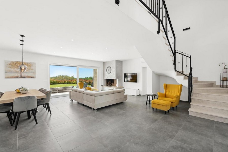 Otevřený obývací a jídelní kout se schodištěm