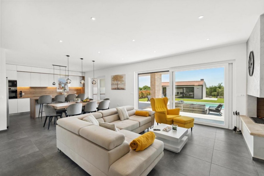 Světlý obývací pokoj se vstupem na terasu a výhled na bazén