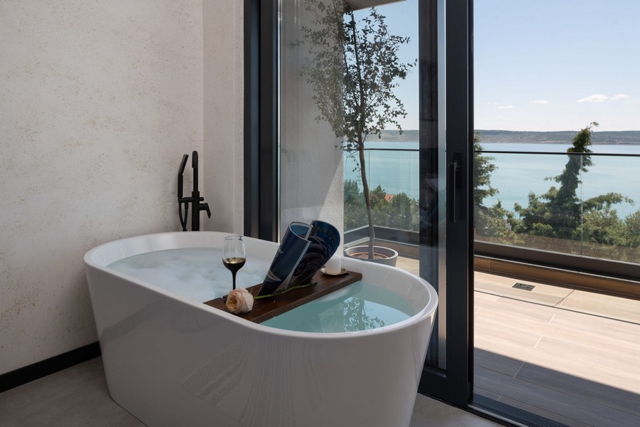 Volně stojící vana u okna s výhledem na moře