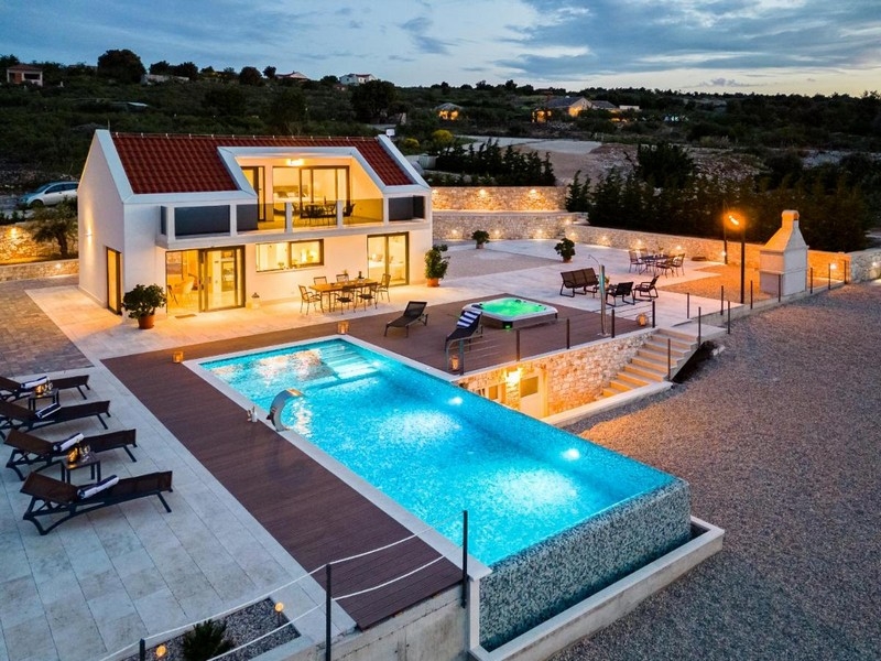Moderní vila s nekonečným bazénem a jacuzzi za soumraku