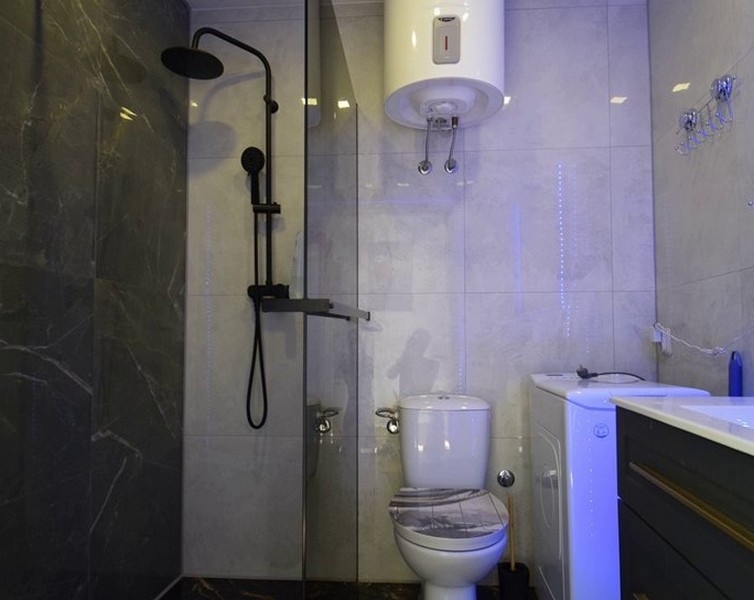 Moderní koupelna se sprchovým koutem a pračkou