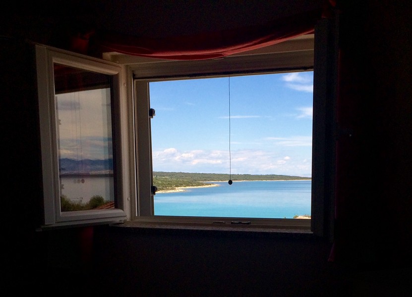 Pohled oknem na pobřeží a moře