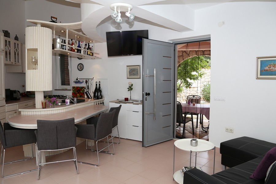 Světlý obývací pokoj s moderní kuchyní a vstupem na terasu