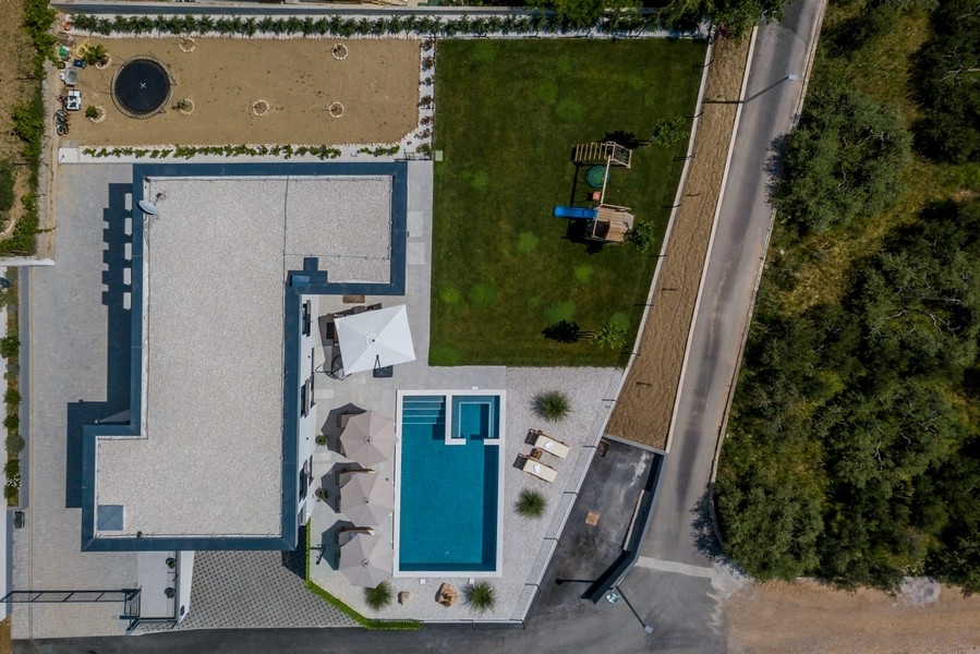 Nemovitost s bazénem, ​​zahradou a dětským hřištěm z ptačí perspektivy