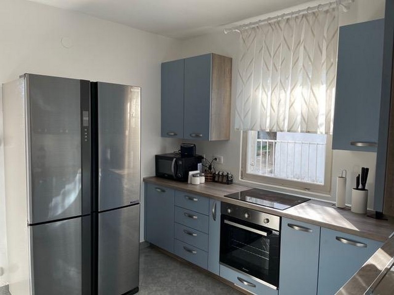 Moderní kuchyňská linka s vestavěnými spotřebiči a oknem