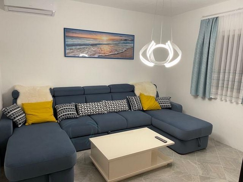 Obývací pokoj s pohovkou a moderním designem osvětlení