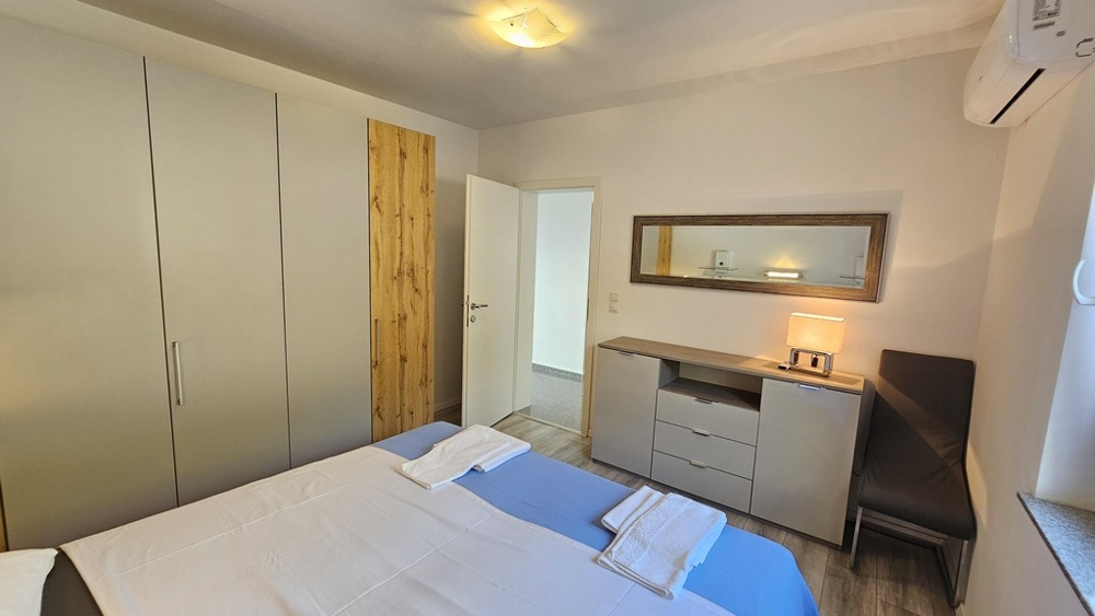 Ložnice se šatní skříní a zrcadlovou komodou