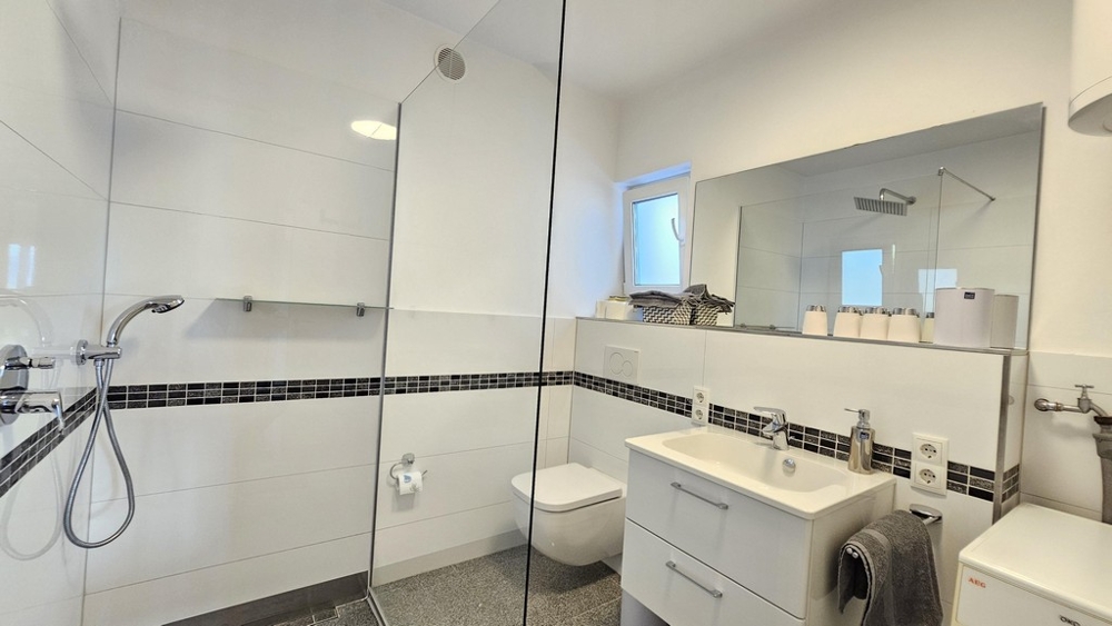 Moderní koupelna se sprchovým koutem a umyvadlem