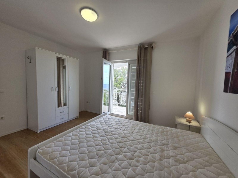 Ložnice s manželskou postelí a vstupem na balkon