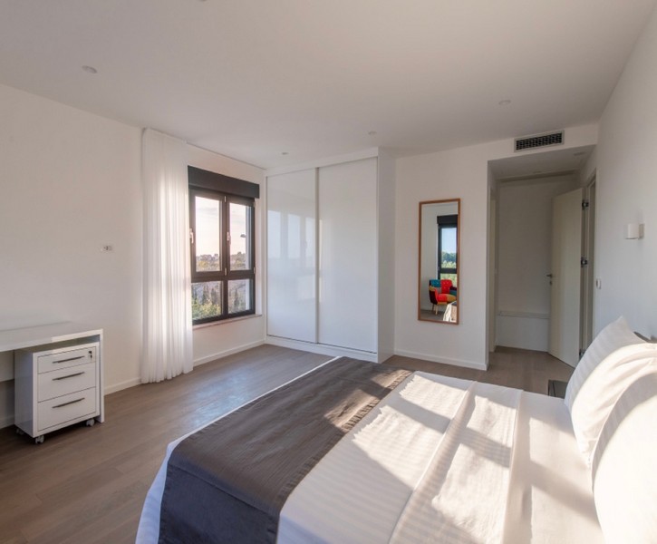 Světlá ložnice s manželskou postelí a vestavěnou skříní