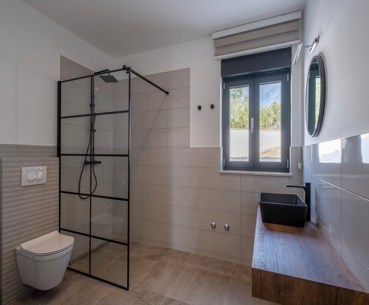 Moderní koupelna s velkým sprchovým koutem a dřevěným umyvadlem