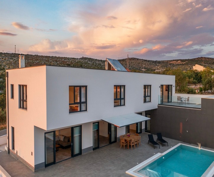 Moderní vila s bazénem při západu slunce na ostrově Brač