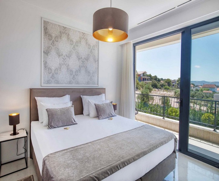 Ložnice s manželskou postelí a vstupem na balkon