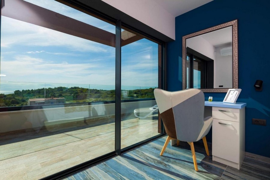 Ložnice s toaletním stolkem a velkým proskleným průčelím na terasu