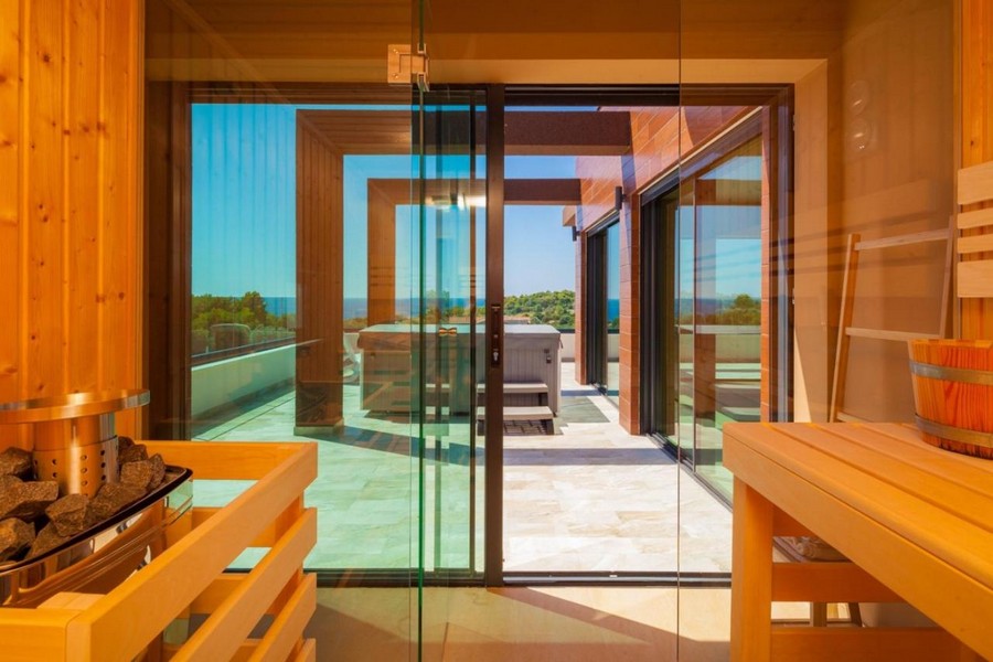 Sauna s proskleným průčelím a vstupem na terasu s výhledem na moře