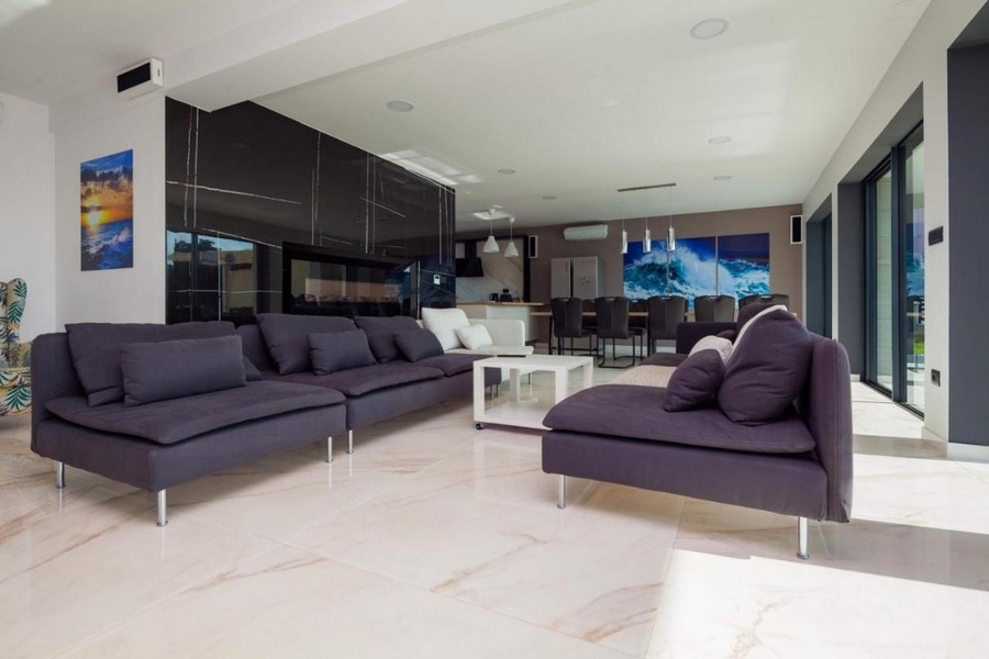 Prostorný obývací pokoj s okny od podlahy ke stropu a moderním nábytkem