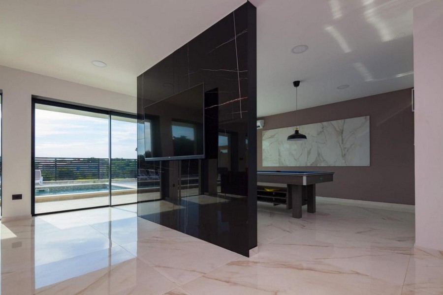 Otevřený obývací prostor s moderními prvky a výhledem na bazén