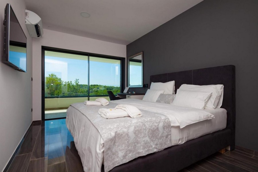 Elegantní ložnice s manželskou postelí a výhledem do krajiny