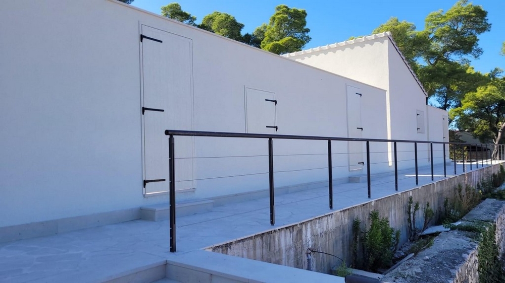 Vnější pohled na moderní dům s bílou fasádou a zábradlím