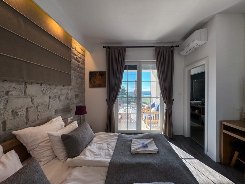 Ložnice s manželskou postelí a vstupem na terasu