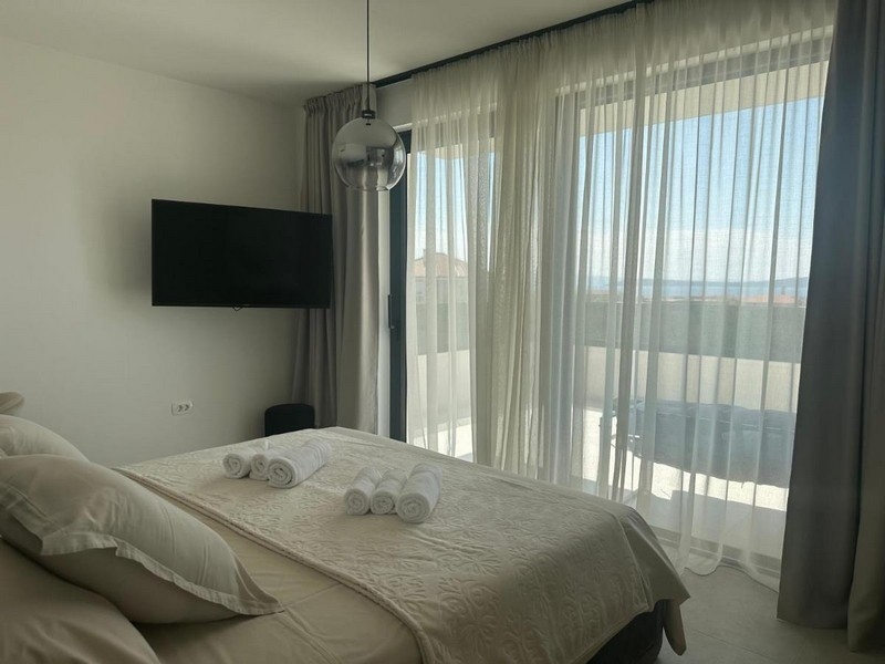 Ložnice s balkonem a výhledem na moře přes velké přední okno