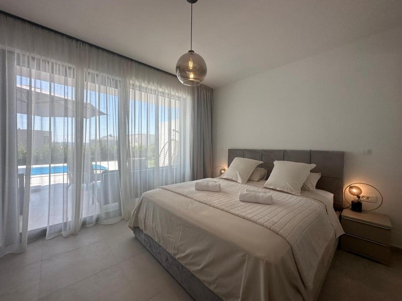 Ložnice s moderním designem a výhledem na bazén