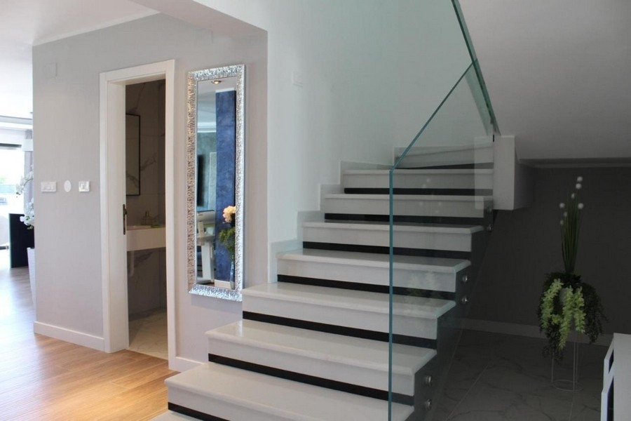 Schodiště se skleněným zábradlím a světlá chodba