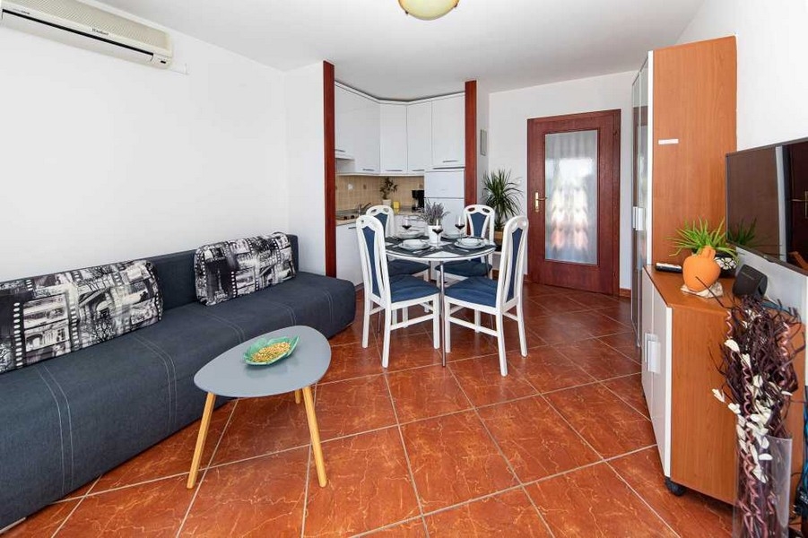 Obývací pokoj s bílou kuchyní a jídelním koutem