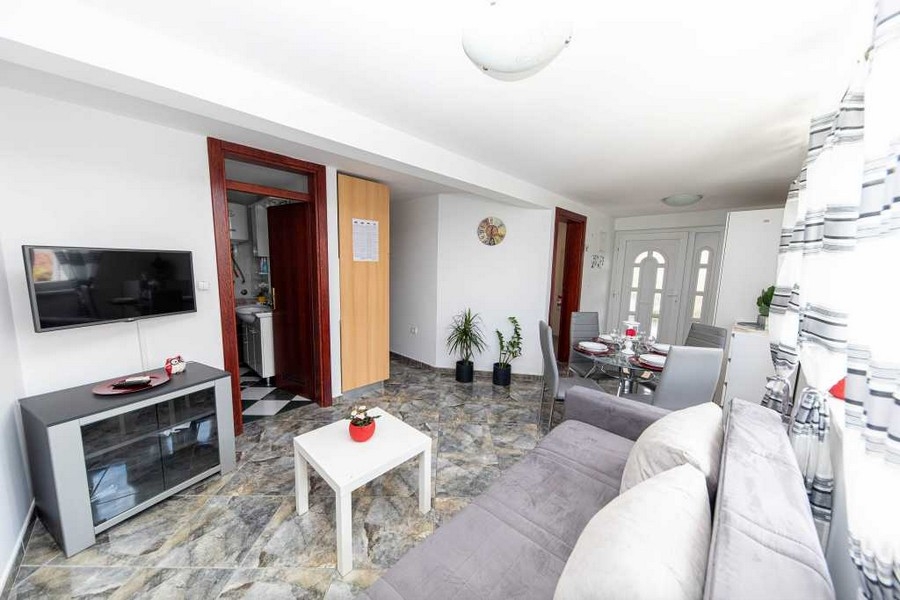 Světlý obývací pokoj s posezením a vstupem do koupelny