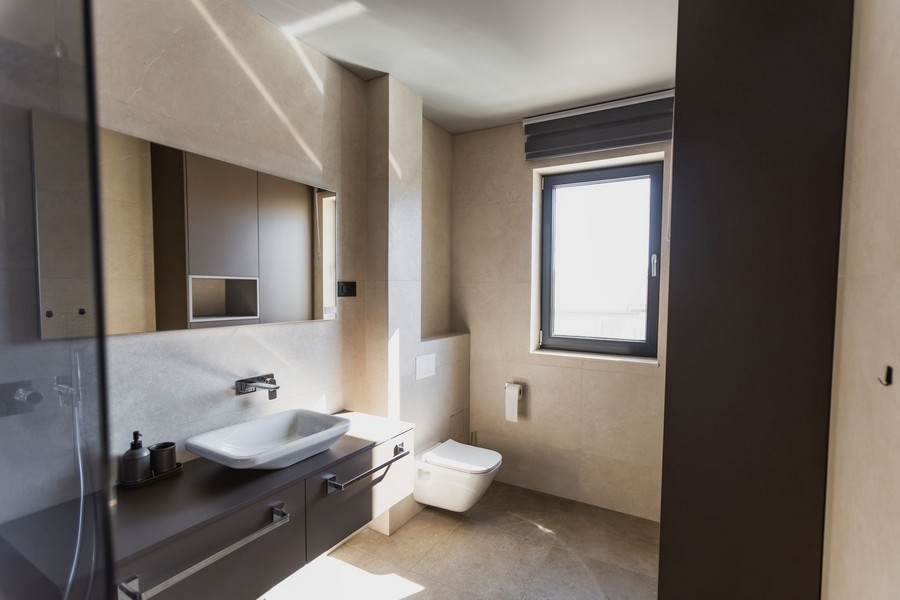 Světlá koupelna s umyvadlem a oknem