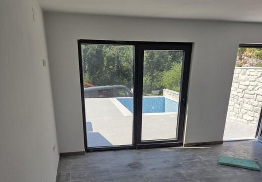 Výhled z interiéru na terasu a bazén