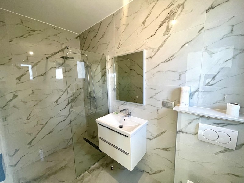 Moderní koupelna se sprchovým koutem a umyvadlem