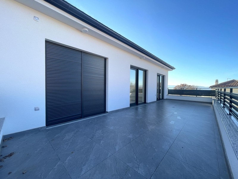 Střešní terasa s výhledem na moře a moderní fasádou