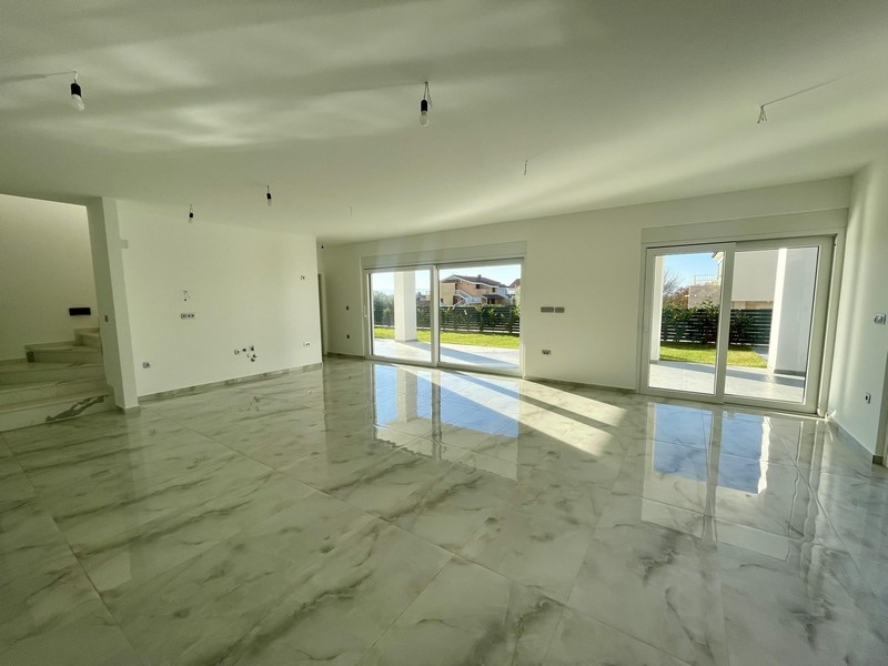 Světlý obývací pokoj s okny od podlahy ke stropu