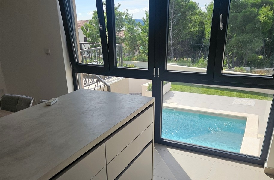 Kuchyňský kout s výhledem na bazén a zahradu