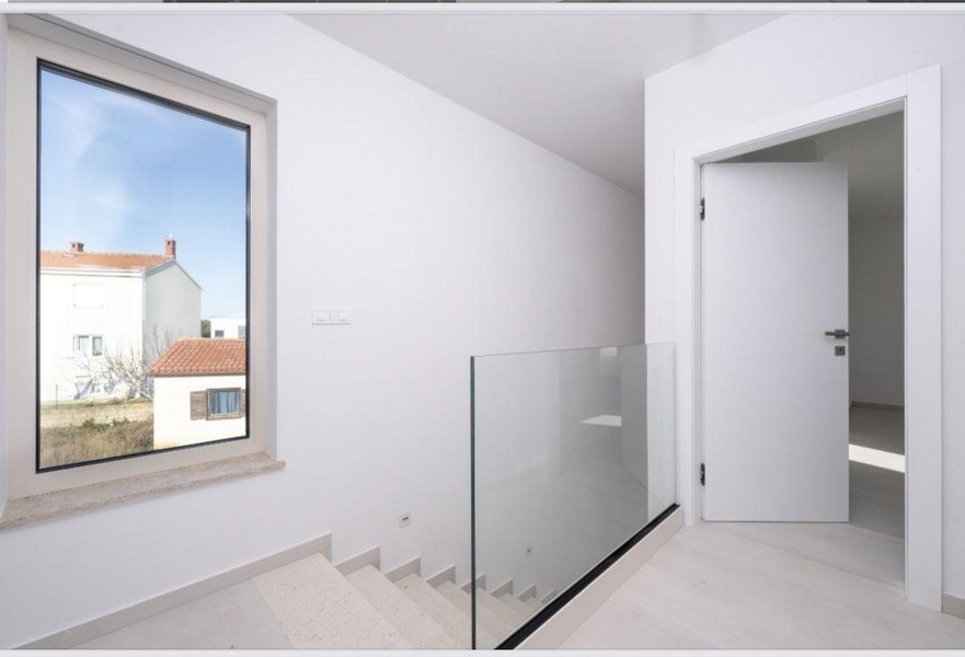 Schodiště se skleněným zábradlím v horním patře