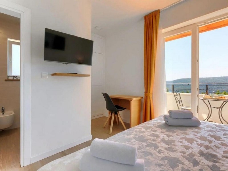 Ložnice se vstupem na balkon a výhledem na moře