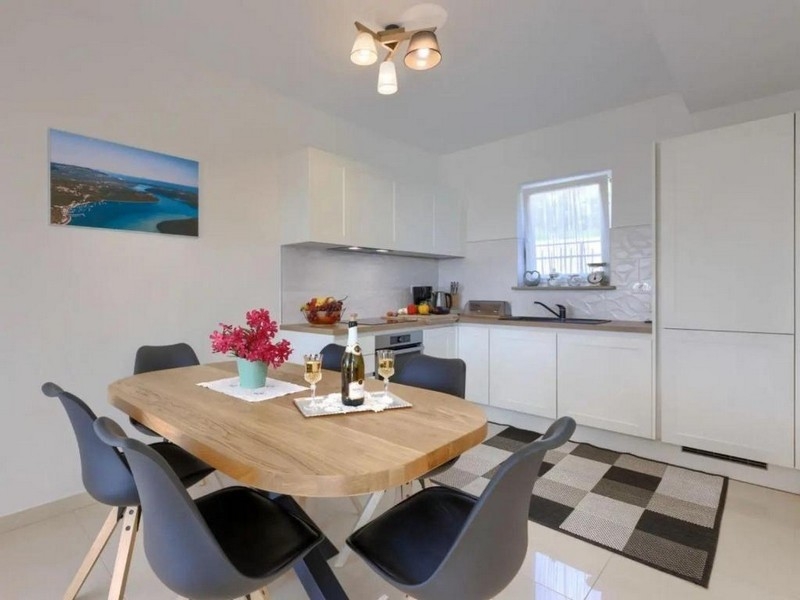 Jídelna s dřevěným stolem a otevřenou kuchyní