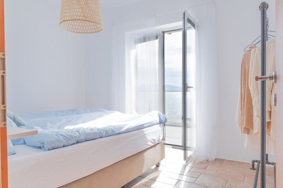 Světlá ložnice s otevřeným výhledem na moře