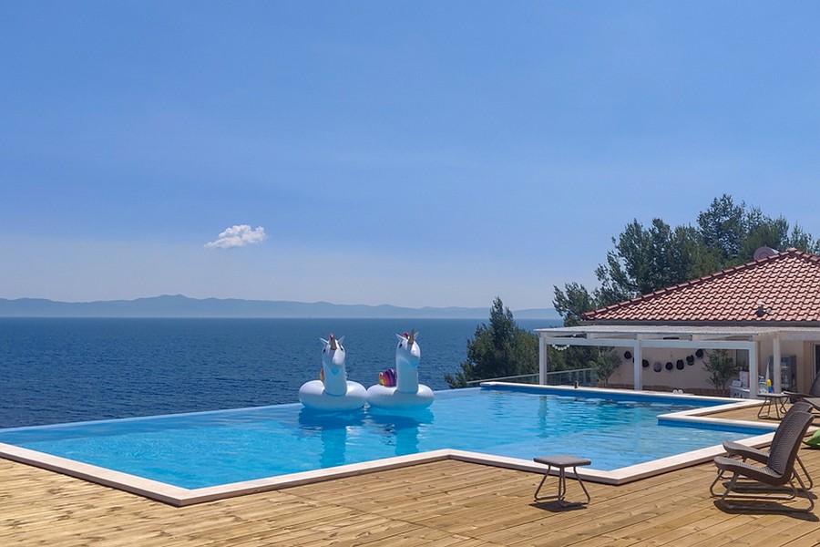 Nekonečný bazén s výhledem na moře a prostornou dřevěnou terasou