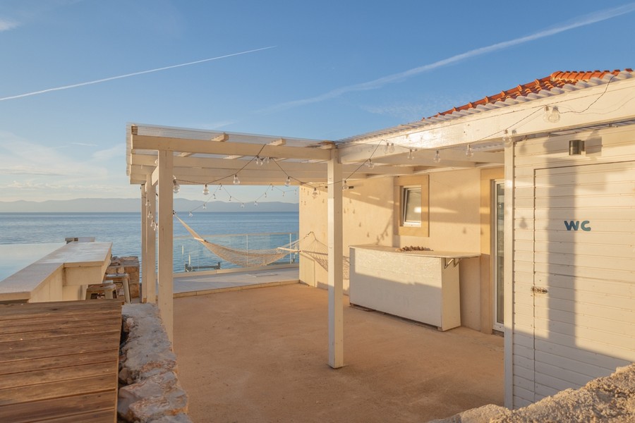 Krytá terasa s venkovním barem a výhledem na moře