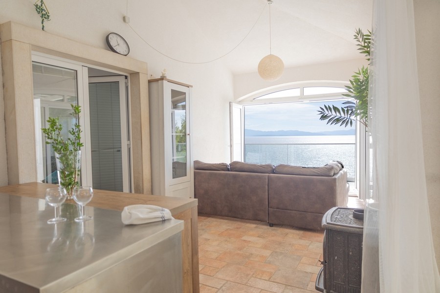 Obývací pokoj s velkým oknem a panoramatickým výhledem na moře